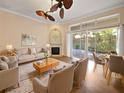 Bright living room with a ceiling fan, fireplace, neutral colors, and sliding glass doors to the patio at 8348 Via Rosa, Orlando, FL 32836