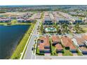 An aerial perspective of a lakeside community with a shared pool and well-maintained residences at 9406 Mere Pkwy, Orlando, FL 32832