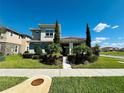 Two-story home with tile roof, manicured landscaping, and walkway to front entrance at 9406 Mere Pkwy, Orlando, FL 32832