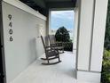 Inviting front porch featuring rocking chairs and a view of the lush, picturesque scenery at 9406 Mere Pkwy, Orlando, FL 32832