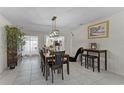 Open dining room featuring tiled floors, view of the kitchen, modern lighting, and a stylish accent chair at 950 Sylvia Dr, Deltona, FL 32725