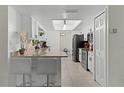 Well-lit kitchen features white cabinetry, granite counters, breakfast bar, and modern stainless appliances at 950 Sylvia Dr, Deltona, FL 32725