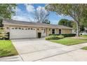 Beautiful home featuring a stone facade, attached garage, and lush green lawn at 1026 Woodall Dr, Altamonte Springs, FL 32714