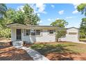 Beautiful single-story home featuring a white exterior, covered porch, and well-manicured landscaping at 1037 N Virginia Ave, Winter Park, FL 32789