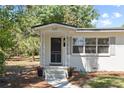 Inviting covered front porch with decorative iron supports and black front door at 1037 N Virginia Ave, Winter Park, FL 32789