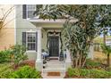 Charming front porch with welcoming decor, decorative columns, and nice landscaping at 14143 Ancilla Blvd, Windermere, FL 34786