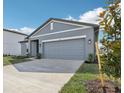 A modern single-Gathering home featuring a two-car garage and landscaped front yard at 1417 Arbor Hill Dr, Deltona, FL 32725