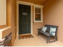 A covered entryway features a charming welcome mat and bench with accent pillows at 14203 Avenue Of The Grvs, Winter Garden, FL 34787