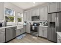 Bright kitchen featuring stainless steel appliances, ample cabinets, and a farmhouse sink at 14203 Avenue Of The Grvs, Winter Garden, FL 34787