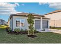 Beautiful one-story home with a well-manicured lawn, gray two-car garage, and newly planted tree at 1453 Arbor Hill Dr, Deltona, FL 32725