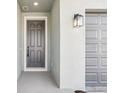 Welcoming front entrance with a gray door, modern lantern, and a gray two-car garage on the right at 1453 Arbor Hill Dr, Deltona, FL 32725