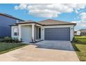 Charming one-story home with a well-manicured lawn, blue paint, and a gray two-car garage at 1453 Arbor Hill Dr, Deltona, FL 32725