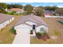 Aerial view of a well-maintained home with a two-car garage and landscaped front yard at 1684 Gopher Tree St, Mascotte, FL 34753