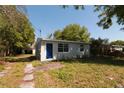 Charming single-story home features a blue front door and well-maintained landscaping at 1801 Riley Ave, Orlando, FL 32805