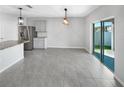 Open concept dining area with sleek gray floors and sliding glass doors to the backyard at 1925 Arbor Mill Ln, Kissimmee, FL 34744