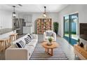 Cozy living room featuring a striped rug, modern furniture, and sliding glass doors to the outdoor space at 1925 Arbor Mill Ln, Kissimmee, FL 34744