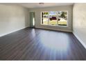 Bright, spacious living room featuring hardwood floors and a large window with a neighborhood view at 214 Cherrywood Dr, Maitland, FL 32751