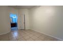 Spacious bedroom with neutral walls and tile flooring, leading to an ensuite bathroom at 2446 Temple Grove Ln, Kissimmee, FL 34741