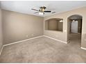 Cozy living room with neutral carpet, a ceiling fan, and an open archway leading to additional living space at 2840 Grasmere View Pkwy, Kissimmee, FL 34746