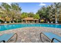 Inviting community swimming pool with a covered pavilion and lounge chairs at 3338 Robert Trent Jones Dr # 20804, Orlando, FL 32835