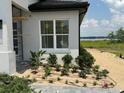 Side yard landscaping with lake view provides a tranquil view and enhances the natural appeal of this newly built property at 336 Caladium Ave, Lake Alfred, FL 33850