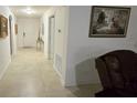 Bright hallway featuring neutral walls, tile floors, framed artwork, and an entryway closet at 3810 Arboreal Ct, Deland, FL 32724