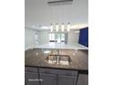 Close-up of kitchen island sink with granite countertops and modern pendant lighting at 3869 Carrick Bend, Kissimmee, FL 34746