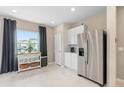 Modern kitchen with stainless steel appliances, white cabinets, and a breakfast bar at 415 Meadowland Pt, Oviedo, FL 32765