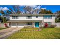 Charming two-story home boasts a well-manicured lawn, two car garage, and a bright blue front door at 533 Little Wekiva Rd, Altamonte Springs, FL 32714