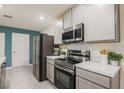 Modern kitchen featuring stainless steel appliances, gray cabinets, and light countertops at 560 Newton Rd, Port Orange, FL 32127