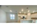 Bright kitchen featuring white cabinets, an island with a quartz countertop, and stainless steel appliances at 5961 Vision Rd, St Cloud, FL 34771