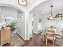 Open-concept dining area featuring wood floors and arched entryways to other rooms at 636 Bainbridge Loop, Winter Garden, FL 34787