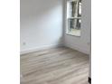 Bright bedroom with white walls, wood-look flooring, a large window and views of the outside at 6889 Se 23 Ave, Ocala, FL 34480
