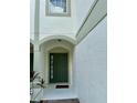 Inviting front entrance with a green door, sidelight window, and arched entryway at 6912 Hochad Dr, Orlando, FL 32819