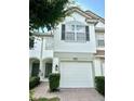 Inviting two-story townhome with a two-car garage, arched entryway, and verdant bushes at 6912 Hochad Dr, Orlando, FL 32819