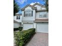 Attractive townhomes with two-car garages, tile roofs, and manicured shrubbery in a shared driveway at 6912 Hochad Dr, Orlando, FL 32819