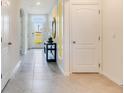 Bright hallway featuring neutral tile flooring, natural lighting, and decorative art at 1344 Hanoverian Dr, Lake Alfred, FL 33850