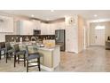 Modern kitchen featuring white cabinets, stainless steel appliances, granite countertops, and bar stool seating at 1656 Moon Valley Dr, Davenport, FL 33896