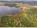 Aerial view of lot outlined in red, backing up to tranquil lake with mature trees at 1680 Blackwelder Rd, De Leon Springs, FL 32130