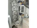Small bathroom with a shower, toilet, vanity, and a cabinet for storage at 333 Lake Howard Nw Dr # 201C, Winter Haven, FL 33880