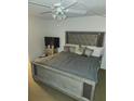 Bedroom with a ceiling fan, television, and large bed with an upholstered headboard at 333 Lake Howard Nw Dr # 201C, Winter Haven, FL 33880
