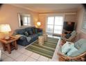 Relaxing living room features comfortable seating, a soft rug, and sliding doors that provide plenty of natural light at 4153 S Atlantic Ave # 1070, New Smyrna Beach, FL 32169