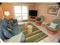 Comfortable living room features a large window, cozy seating, and a decorative rug for a relaxing atmosphere at 4153 S Atlantic Ave # 1070, New Smyrna Beach, FL 32169