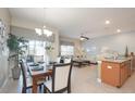 Open-concept dining room with modern light fixture and adjacent living room area at 4879 Clock Tower Dr, Kissimmee, FL 34746