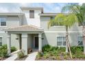 Inviting townhome exterior with well-maintained landscaping and covered front porch entry at 4879 Clock Tower Dr, Kissimmee, FL 34746