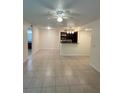 Bright living room with tile flooring that leads to a modern kitchen with stainless steel appliances at 5120 Conroy Rd # 513, Orlando, FL 32811