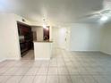 Open-concept living space with tile flooring and a breakfast bar that looks into the stainless steel kitchen at 5120 Conroy Rd # 513, Orlando, FL 32811