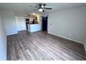 Bright living room featuring wood floors, a ceiling fan, and easy access to kitchen at 5128 Conroy Rd # 725, Orlando, FL 32811