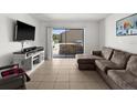 Living room featuring a sectional sofa and a sliding glass door to a patio area at 5201 Vineland Rd # 112, Orlando, FL 32811