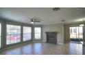 Bright living room featuring tile flooring, large windows, a ceiling fan, and a cozy fireplace at 634 Steamboat Ct # 171, Altamonte Springs, FL 32714